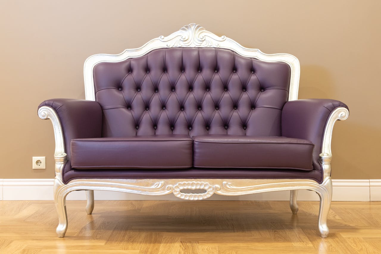 Luxurious vintage leather sofa with tufted upholstery and ornate frame, ideal for classic interiors.